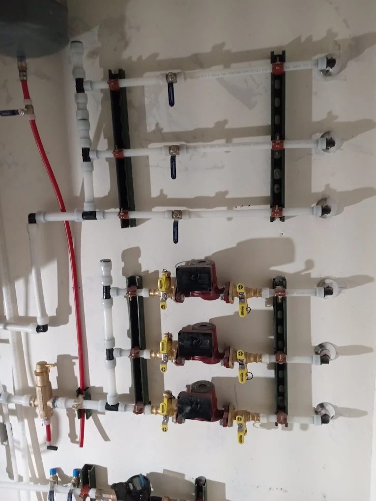 In-wall plumbing and heating system installation with manifolds and brass fittings